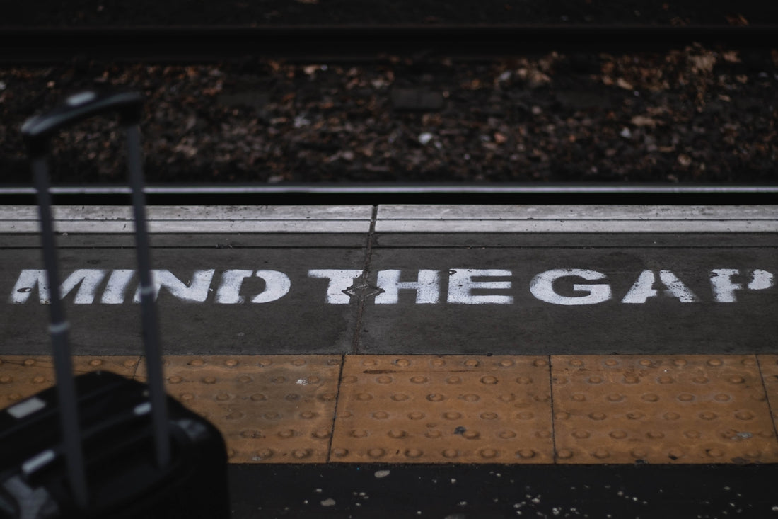 a piece of luggage sitting on the side of a train track