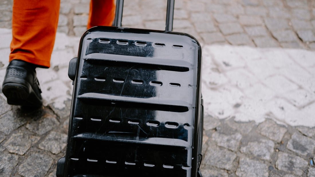 a person walking with a black piece of luggage