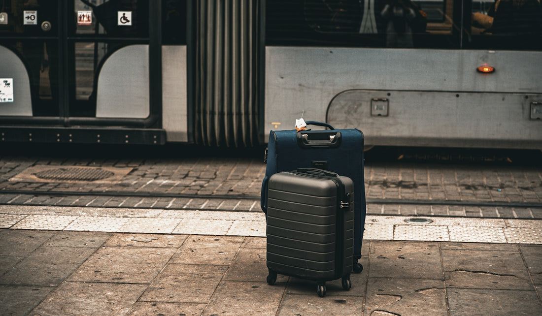A suitcase sitting on the ground in front of a bus